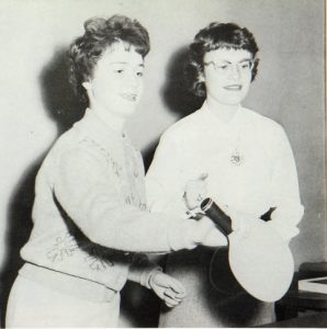 Two ladies pose with ping pong paddles in the Towers Vandybilt Lounge in 1961