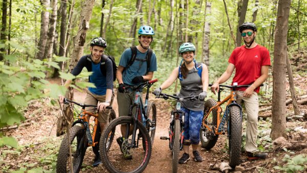 Adventure Education and Outdoor Leadership students pose with their bikes in a forest.