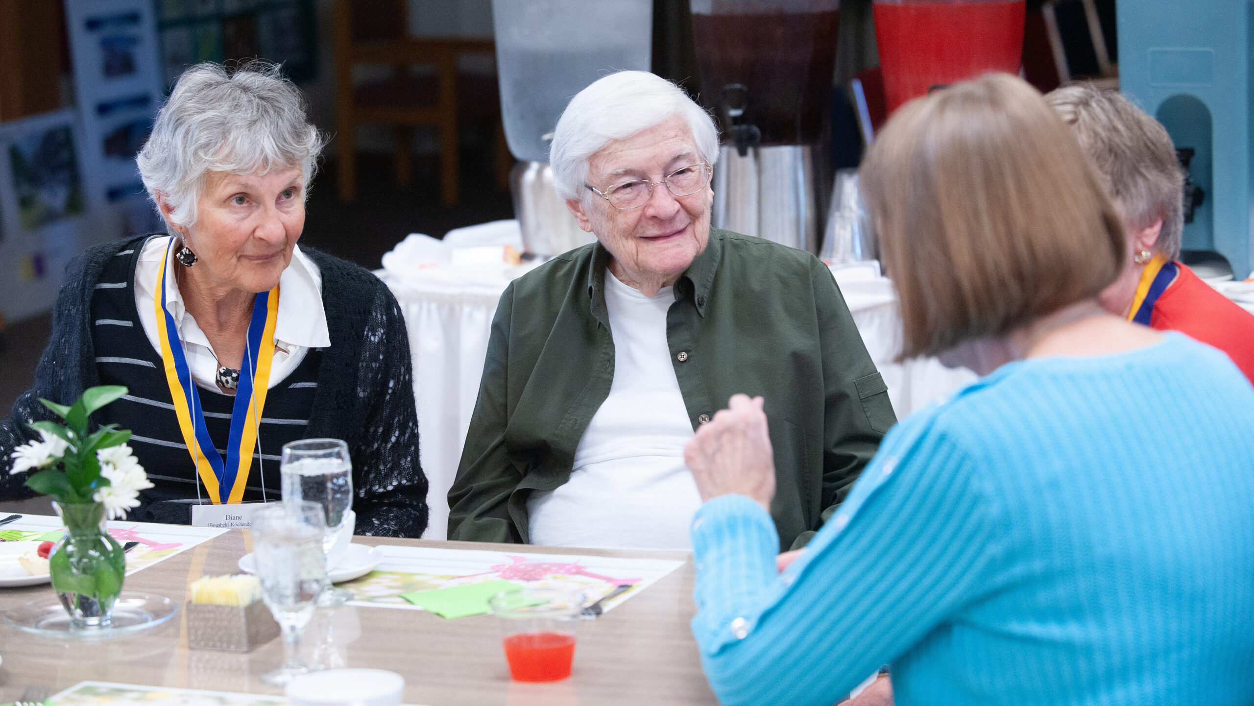 Four alumni gathered at a table at Reunion 2023.