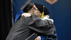 President McDonald embraces Owen Erickson at his commencement ceremony.