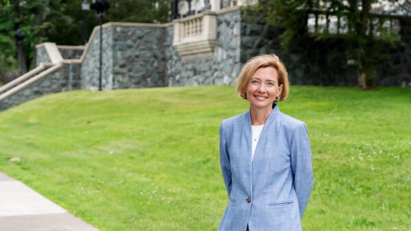 Photo of St. Scholastica president, Brenda Kelly in front of Tower Hall.