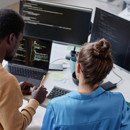 Photo of two students working together on a computer programming project