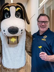 Dave Gunnarson poses with St. Scholastica's mascot, Storm.