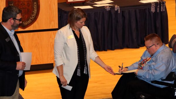 Ryan Sandefer and Dory Kempf presenting a student with the Tri Alpha Induction award.