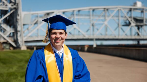 Photo of St. Scholastica's 2025 Commencement Speaker Jason Amireault in front of the lift bridge