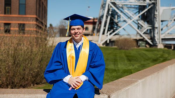 Photo of St. Scholastica's 2025 Commencement Speaker Jason Amireault in front of the lift bridge