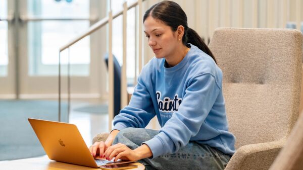 St. Scholastica student working on their laptop.