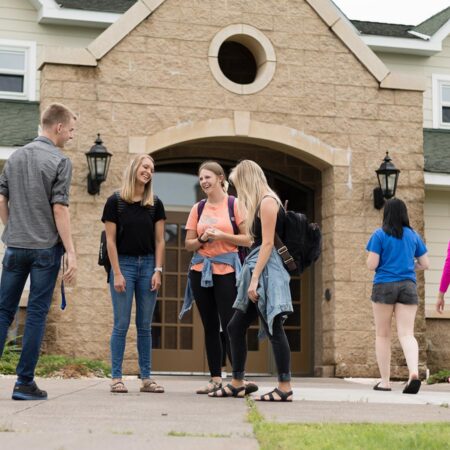 Photo of a group of students gathered outside of a dorm