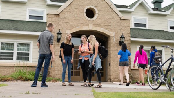 Photo of a group of students gathered outside of a dorm