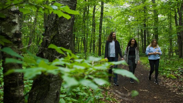 A group of St. Scholastica students working with the NatureRx program walking through the woods.