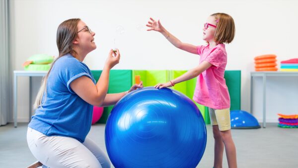 An occupational therapist works with a child on their coordination. Pediatric OT is one of the major occupational therapy practice areas.