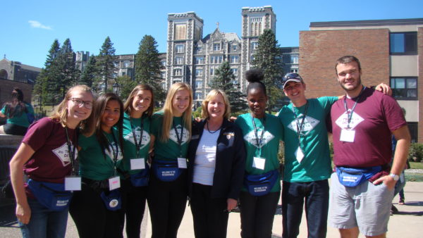 A tour group poses in front of Tower Hall