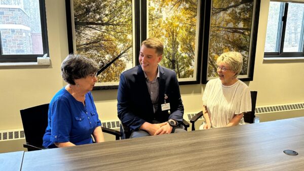 Luke Wessberg with colleagues in a conference room.