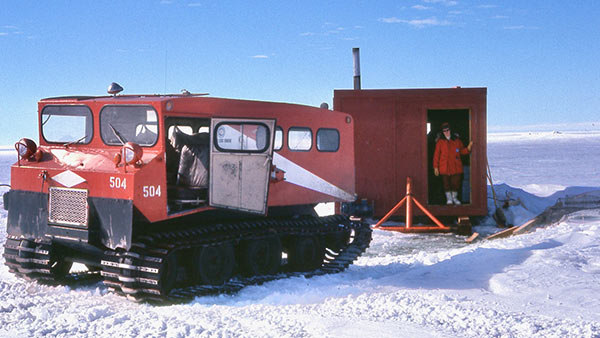 Sister Mary Odile Cahoon standing in the doorway of a mobile sampling hut in McMurdo Sound