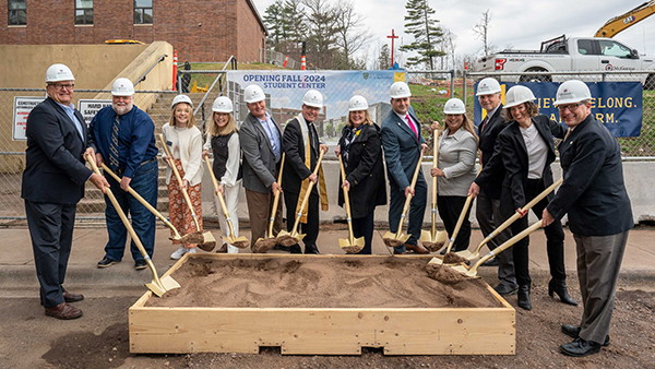 Representatives from St. Scholastica, HGA, and McGough pose with golden shovels and construction gear.