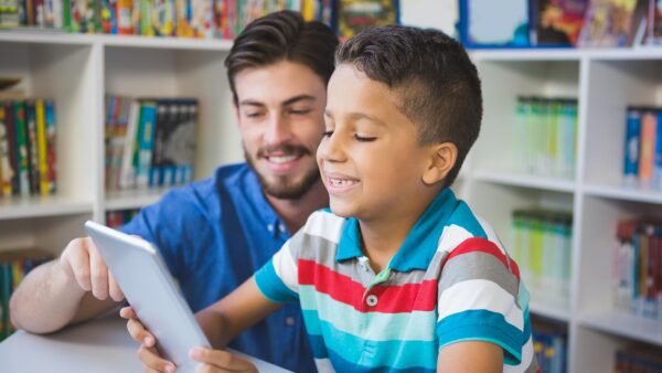 A photo of a teacher helping a student read