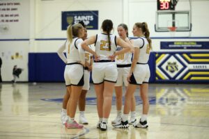 Members of the St. Scholastica Women's Basketball team huddled.