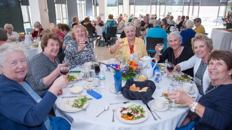A group of St. Scholastica alumni make a toast together at the reunion