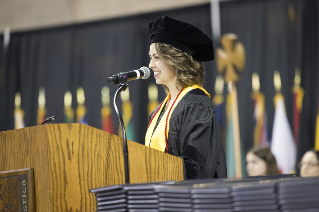 Amy Leopold speaking at podium as one of the commencement speakers.