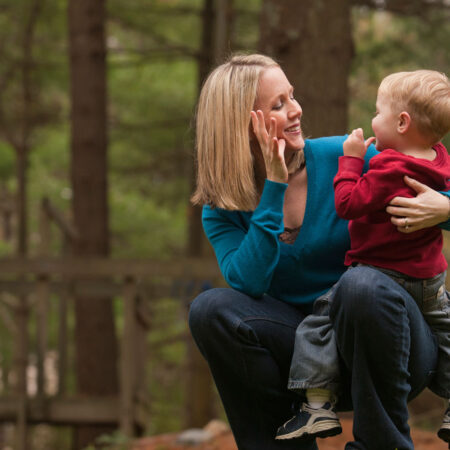A mother holding and signing to her child.
