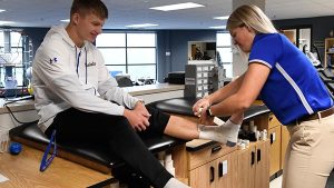 Athletic Training wrapping a person's ankle in the St. Scholastica Athletic Training Facility