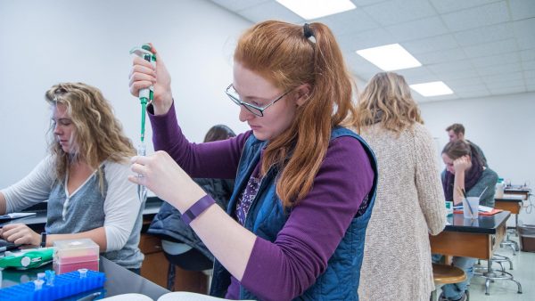 St. Scholastica student conducting an experiment in a science lab.