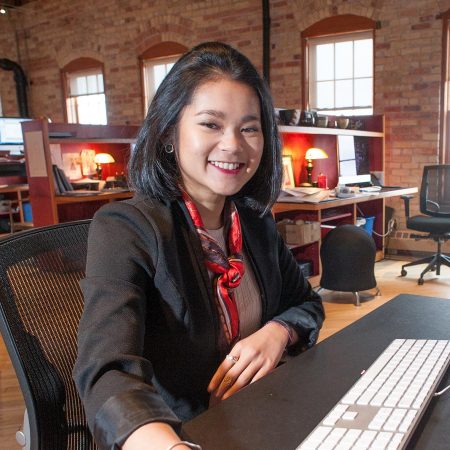 Graduate, Zhara Davies working in an office setting.