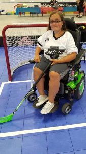 Chelsea Knutson sitting in front of the hockey net.