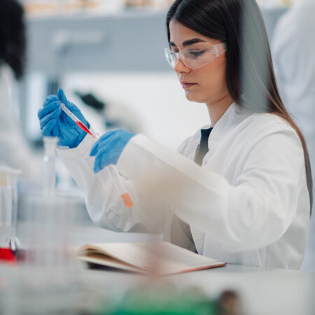 Student working on a laptop in a chemistry lab.