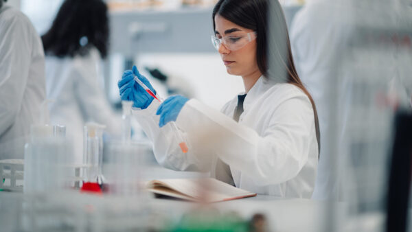 Student working on a laptop in a chemistry lab.