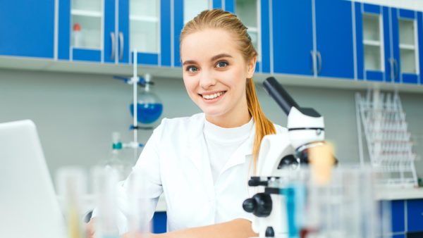 Student working on a laptop in a chemistry lab.