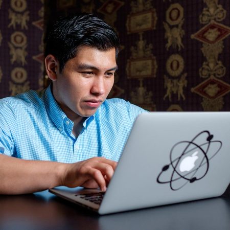 CIS graduate Leonardo Parra coding on his computer at a remote location.