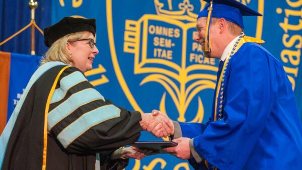 President McDonald congratulating a student on his graduation.