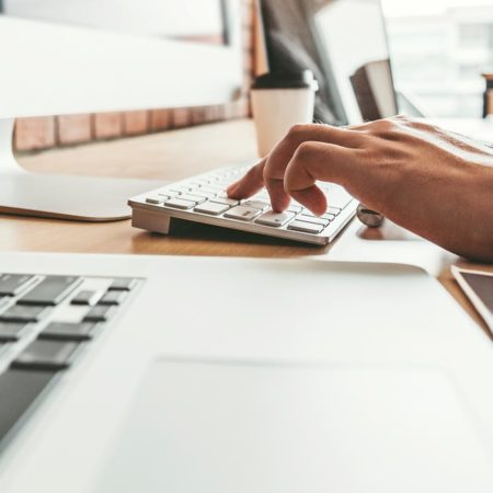 Person tying on a computer keyboard.