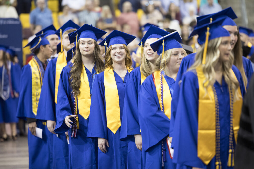 Graduates lined up and smiling.