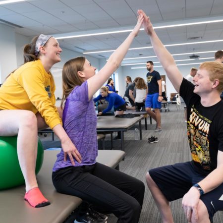 St. Scholastica students learning physical therapy techniques in the Mat Lab.