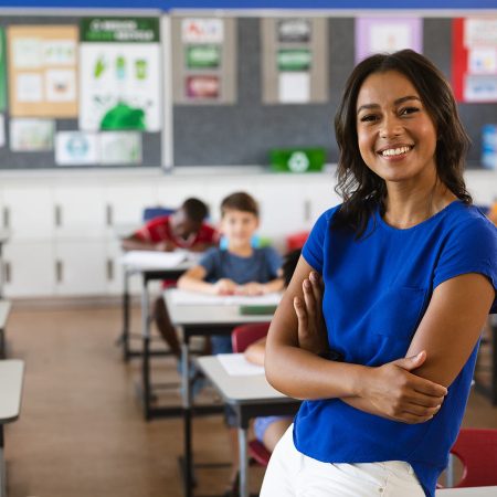 Graduate, Jebah Edmunds standing in her classroom.