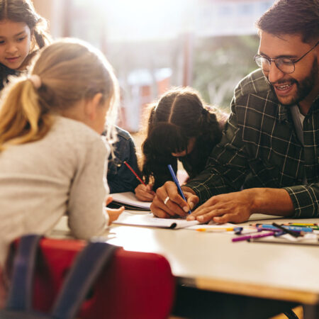 A teacher helping students with coursework in class.