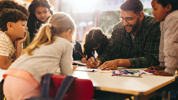 A teacher helping students with coursework in class.