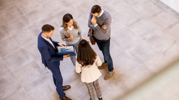 A young leader speaking to a group of corporate professionals.