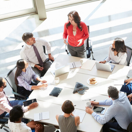 A young leader speaking to a group of corporate professionals.