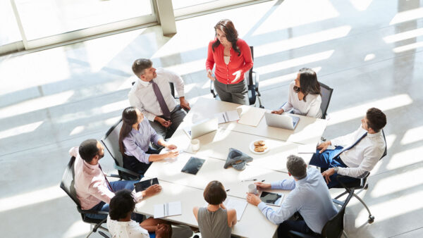 A young leader speaking to a group of corporate professionals.