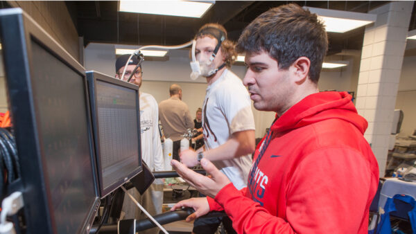 A runner on a treadmill being monitored by exercise physiology equipment.