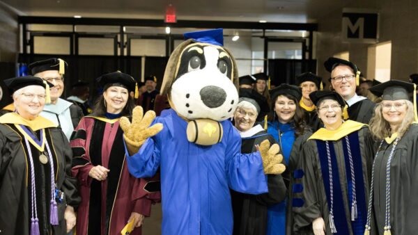 Faculty gathered with Storm for a photo.