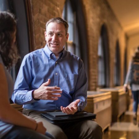 Student and faculty talking in the Cloister Walk.