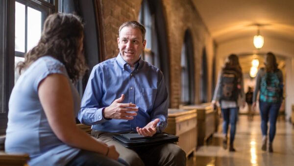 Student and faculty talking in the Cloister Walk.