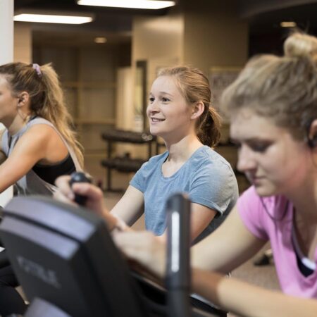A group of 3 students working out in the Burns Wellness Commons fitness center.
