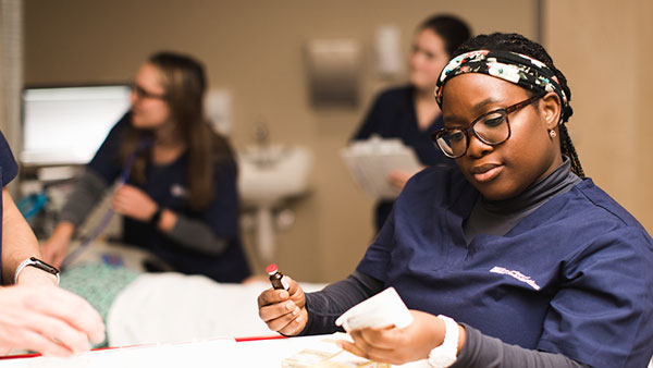 St. Scholastica nursing students working in a clinical setting.