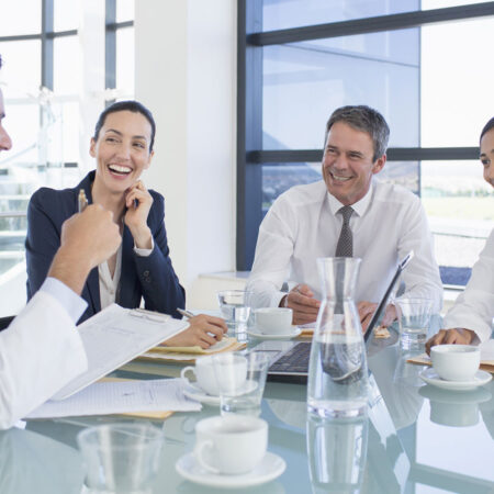 A group of healthcare professionals networking with business executives in a conference room setting.