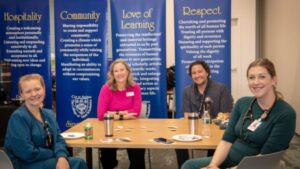 Four healthcare professionals sitting at a table together.